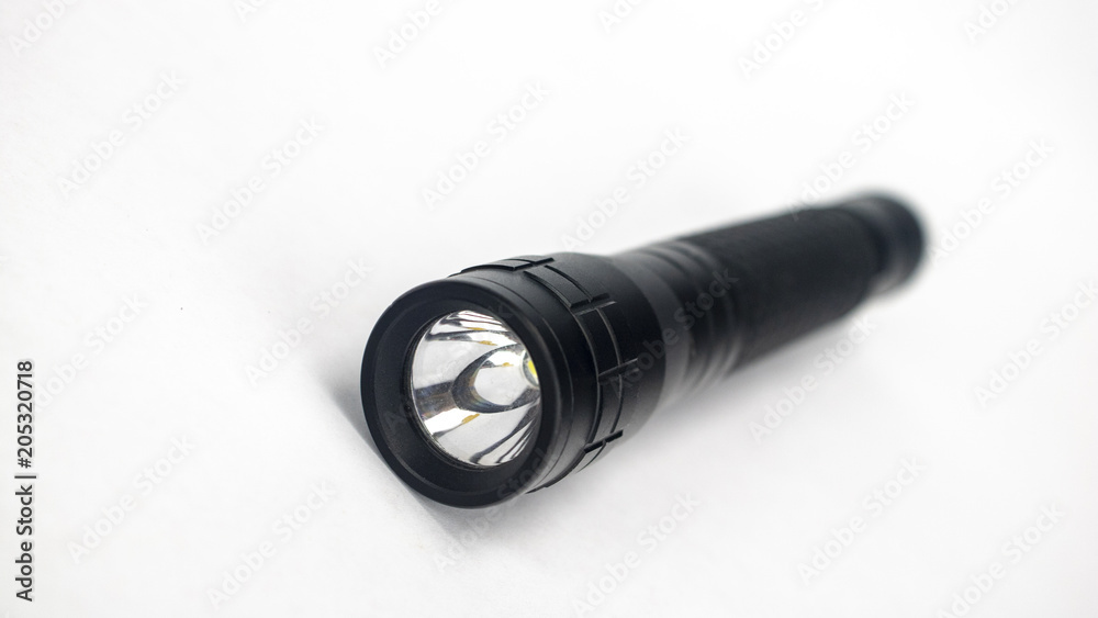 A black flashlight on an isolated white background A black flashlight on an isolated white background