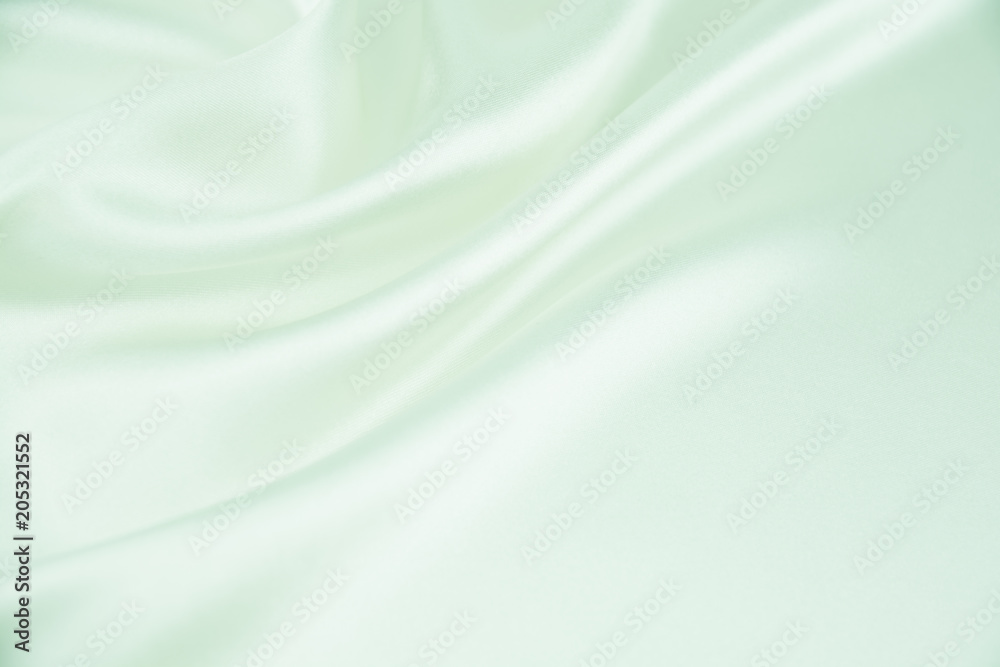 The texture of the satin fabric of green color for the background The texture of the satin fabric of green color for the background