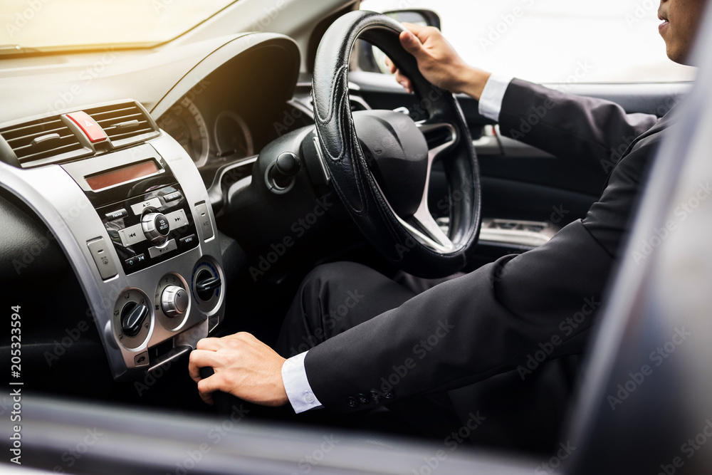 Portrait of a young handsome businessman driving a luxury sports car (rich)