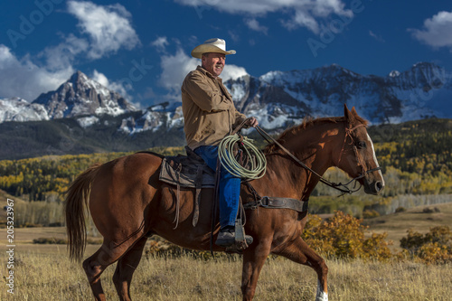 Cowboy rides horse across historic Last Dollar Ranch on Hastings Mesa, SW Colorado, San Juan Mountains © spiritofamerica