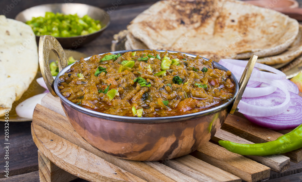 Indian Cuisine Sev Tamatar Also Called Sev Tamaeta or Sev Tameta is Served With Chapati, Papad, Onion or Raita. It is Made With Tomato And Onion Gravy With a Twist of Spicy Sev on Wooden Table Indian Cuisine Sev Tamatar Also Called Sev Tamaeta or Sev Tameta is Served With Chapati, Papad, Onion or Raita. It is Made With Tomato And Onion Gravy With a Twist of Spicy Sev on Wooden Table