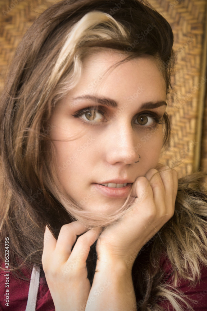 Head and shoulders portrait of young woman in window light. Head and shoulders portrait of young woman in window light.