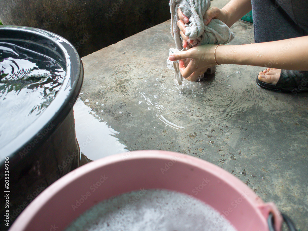 Fototapeta premium Girls wash the laundry beside the house to clean the house.