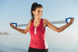 Smiling sports woman doing exercise with hand expander