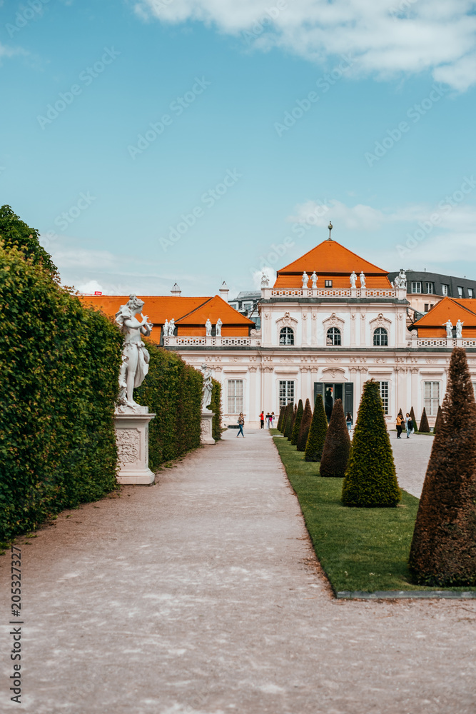 Antique sculpture and Belvedere garden with clipped bushes in Vienna, Austria in a beautiful spring day
