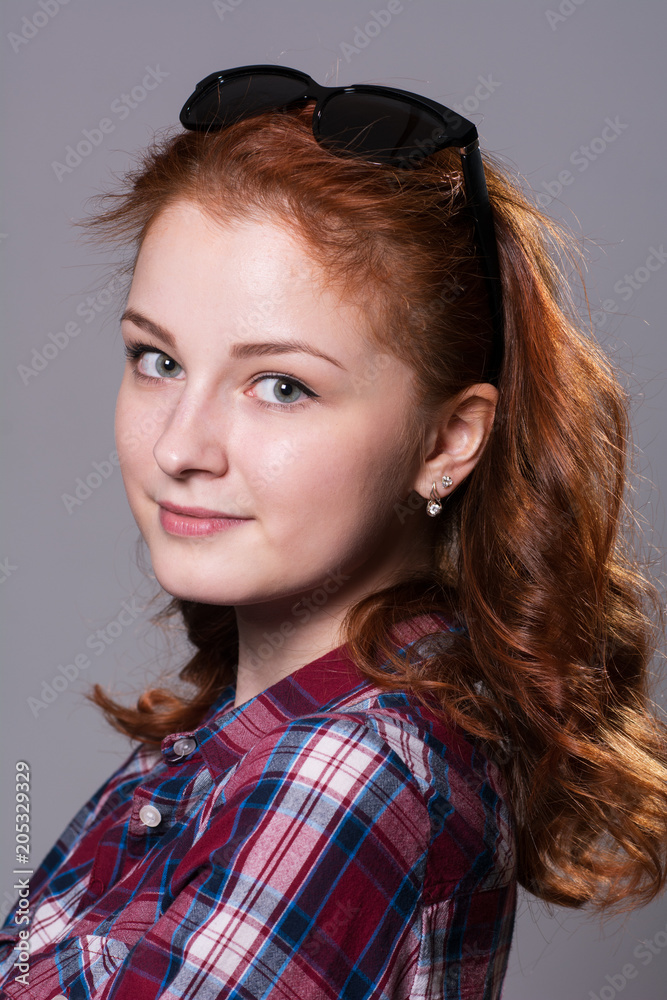 Fototapeta premium Portrait of smiling girl with sunglasses on head looking at camera