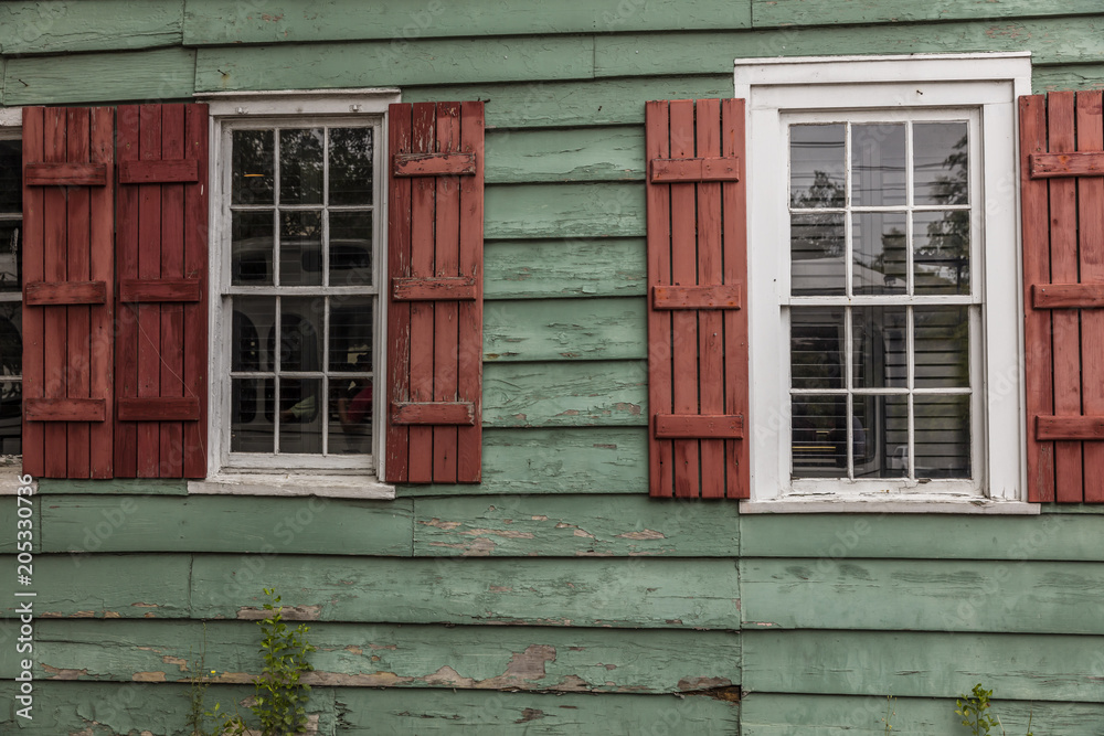 JUNE 26, 2017 - SAVANNAH GEORGIA - Historic siding of home features red shudders and green siding old wood - 