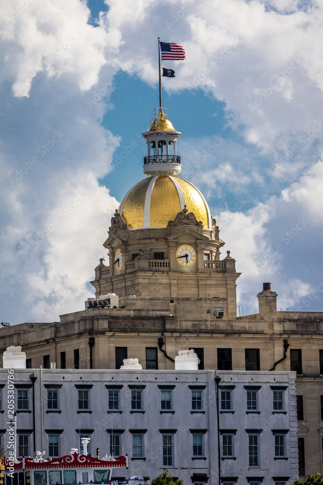 Fototapeta premium JUNE 28, 2017 - SAVANNAH GEORGIA - Historic Savannah City Hall Clock Tower and Gold Dome with US Flag flying