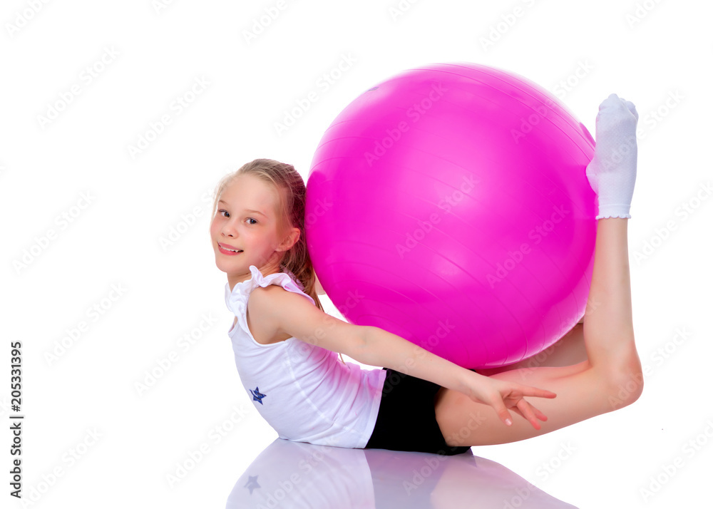 little girl doing exercises on a big ball for fitness. little girl doing exercises on a big ball for fitness.
