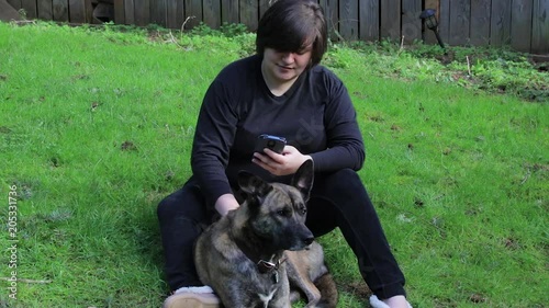 girl sitting with a dog and her phone photo