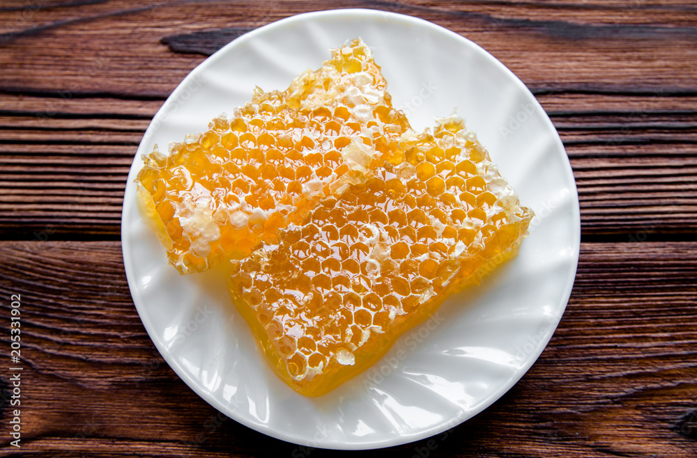 honey in honeycombs on a white plate honey in honeycombs on a white plate