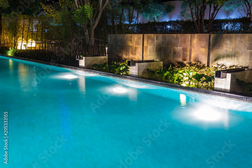 Pool lighting in backyard at night for family lifestyle and living area.  Luxury design with good light and clean landscaping. © Travis