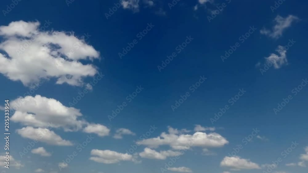 movement of white clouds against a blue sky. movement of white clouds against a blue sky.