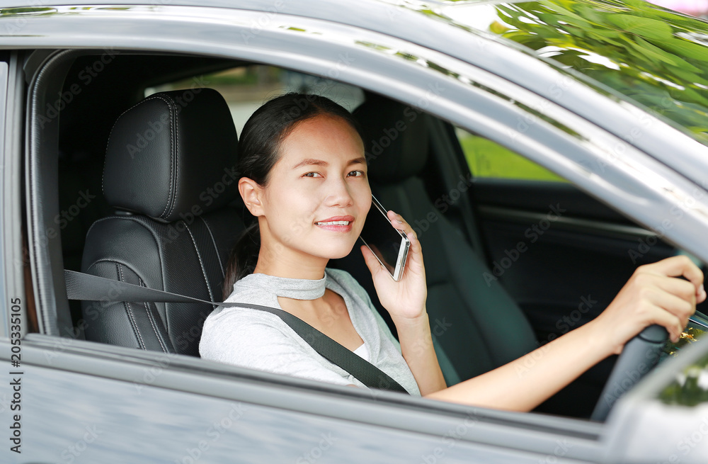 Woman driver using her mobile phone while driving car.