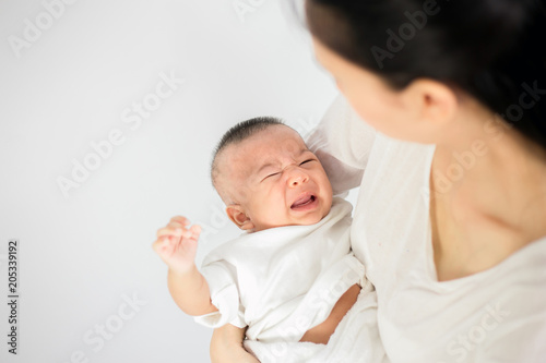 Mother trying to comfort her crying baby isolated