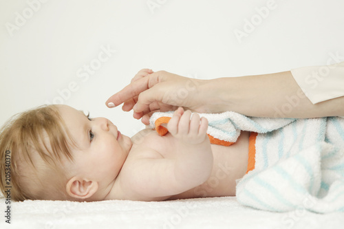 Baby handling: Woman applying moisturizing cream on her baby's face