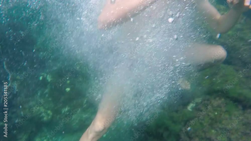 Young male jumping cannon ball into water from low cliff, active holidays, fun Young male jumping cannon ball into water from low cliff, active holidays, fun