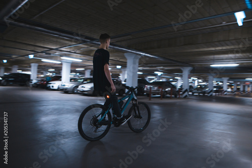 Riding a bike without hands on underground parking. An extreme man rides a bike on the parking lot