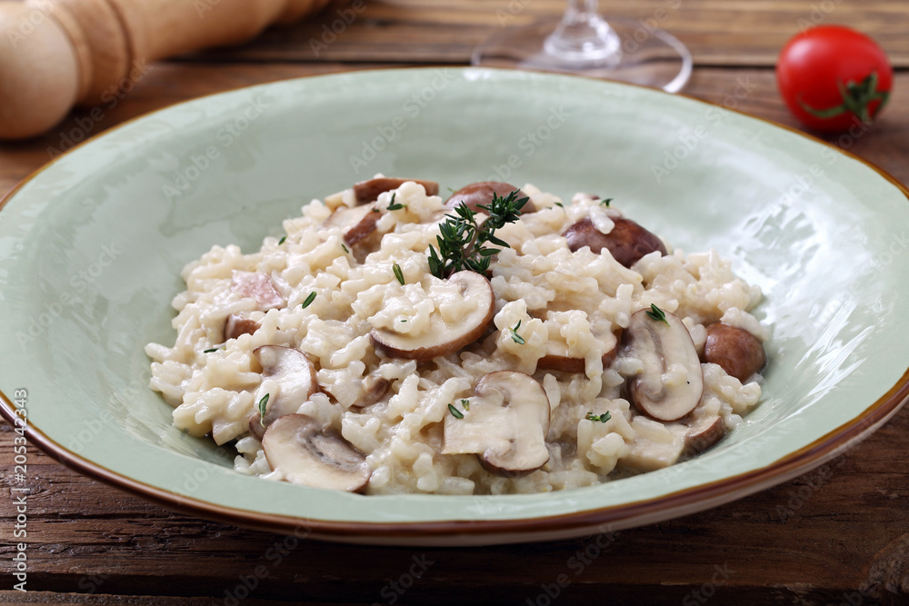 risotto con funghi tradizionale italiano su sfondo tavolo di cucina rustico risotto con funghi tradizionale italiano su sfondo tavolo di cucina rustico