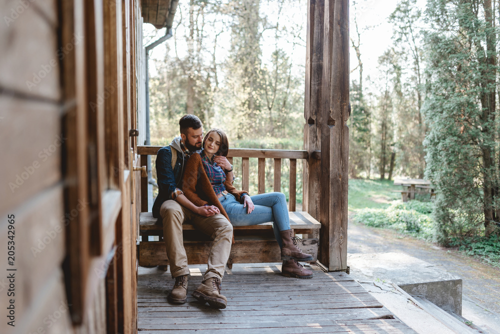 young couple hipster sitting on a bench on the terrace young couple hipster sitting on a bench on the terrace
