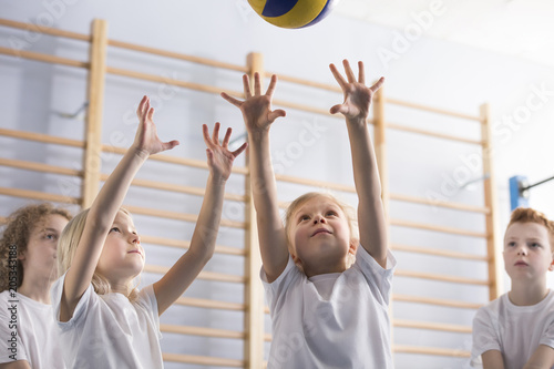 Girl jumping to bounce volleyball