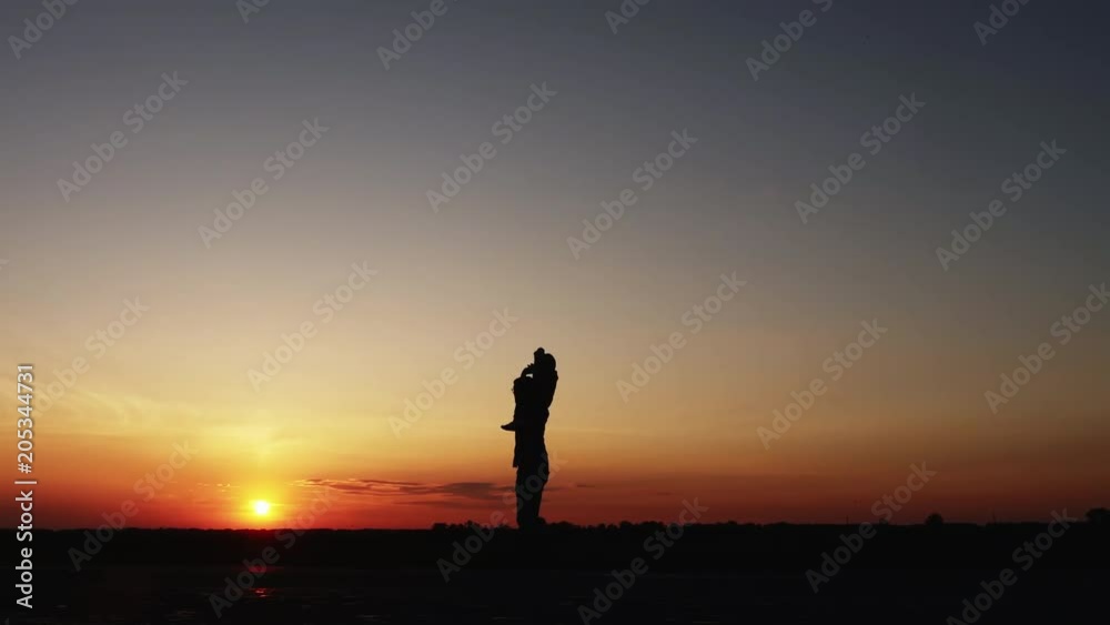 Silhouettes of father playing with little son at sunset. The boy is sitting on his shoulders. Dolly shot. Slow motion Silhouettes of father playing with little son at sunset. The boy is sitting on his shoulders. Dolly shot. Slow motion