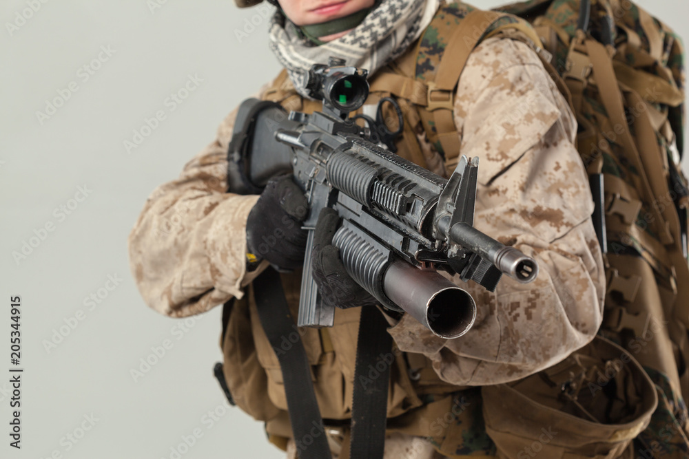 Soldier in camouflage holding rifle Soldier in camouflage holding rifle