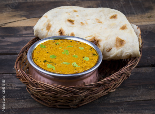 Indian Vegetarian Cuisine Dal Makhani Also Know as Dal Makhni or Daal Makhani is A Popular Dish From Punjab, Cooked With Black Lentil, Red Kidney Beans, Butter And Cream. on Vintage Wooden Background photo