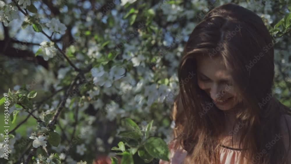 Beauty young caucasian woman enjoying nature in spring apple orchard, Happy Beautiful girl in Garden with blooming trees. Slow motion video shooting by handheld gimbal Beauty young caucasian woman enjoying nature in spring apple orchard, Happy Beautiful girl in Garden with blooming trees. Slow motion video shooting by handheld gimbal