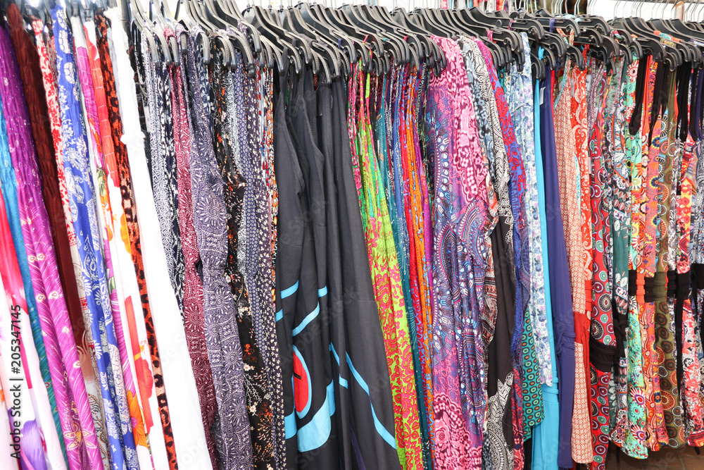 Variety of woman casual different female floral clothes hanging in store