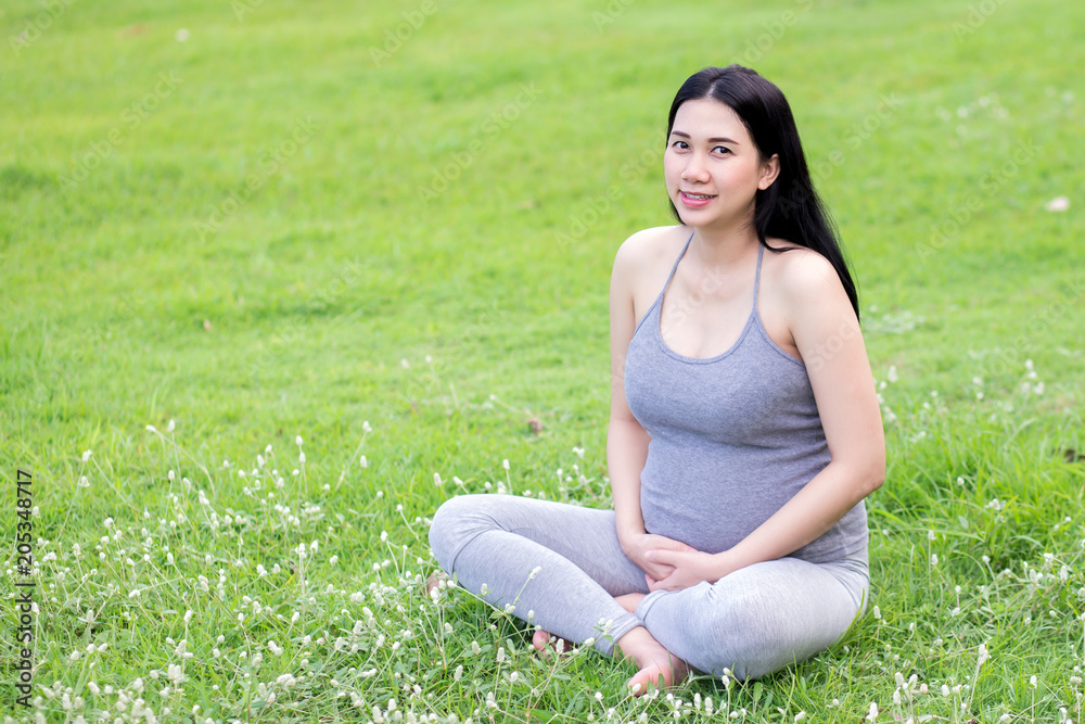 Healthy pregnant woman doing yoga in nature outdoors. Close up Healthy pregnant woman doing yoga in nature outdoors. Close up