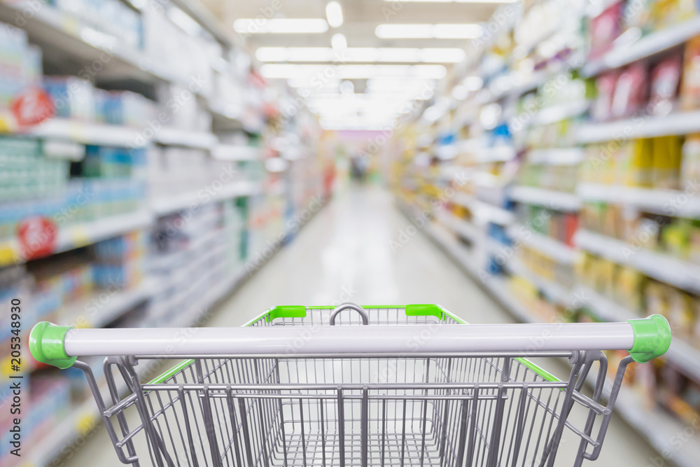 Supermarket aisle with empty shopping cart at grocery store retail business concept Supermarket aisle with empty shopping cart at grocery store retail business concept