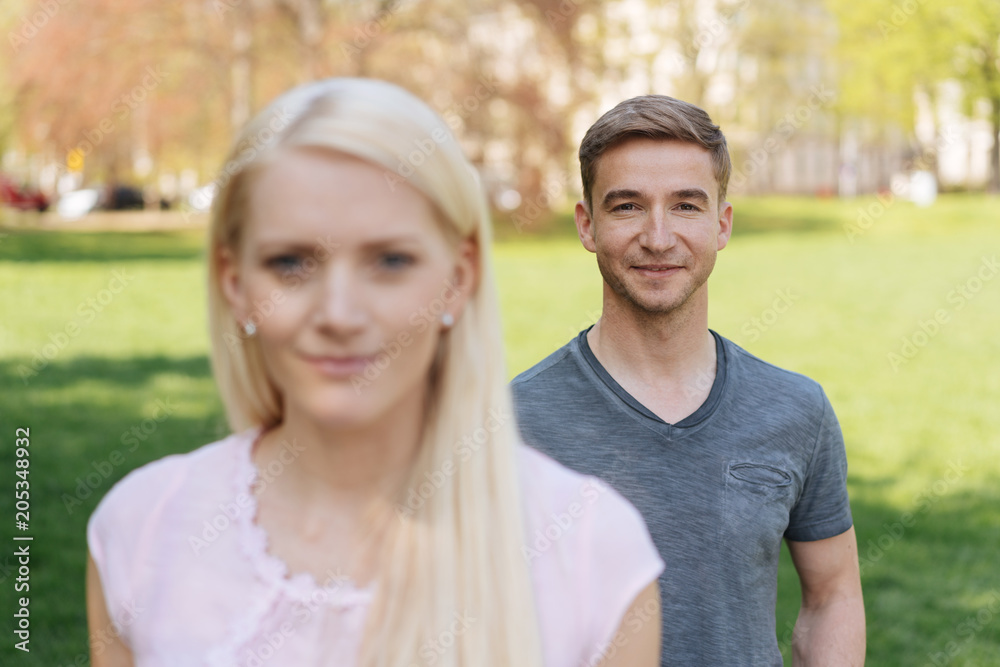Young couple standing outdoors in an urban park Young couple standing outdoors in an urban park
