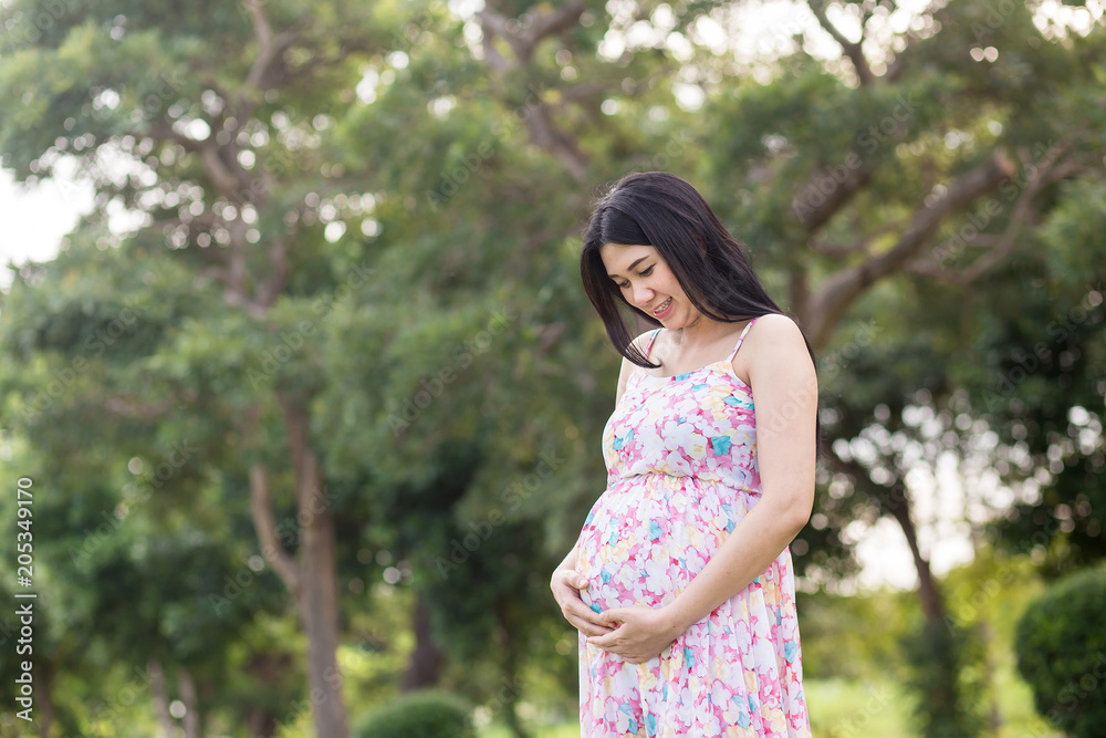 Beautiful pregnant woman relaxing outside in the park Beautiful pregnant woman relaxing outside in the park