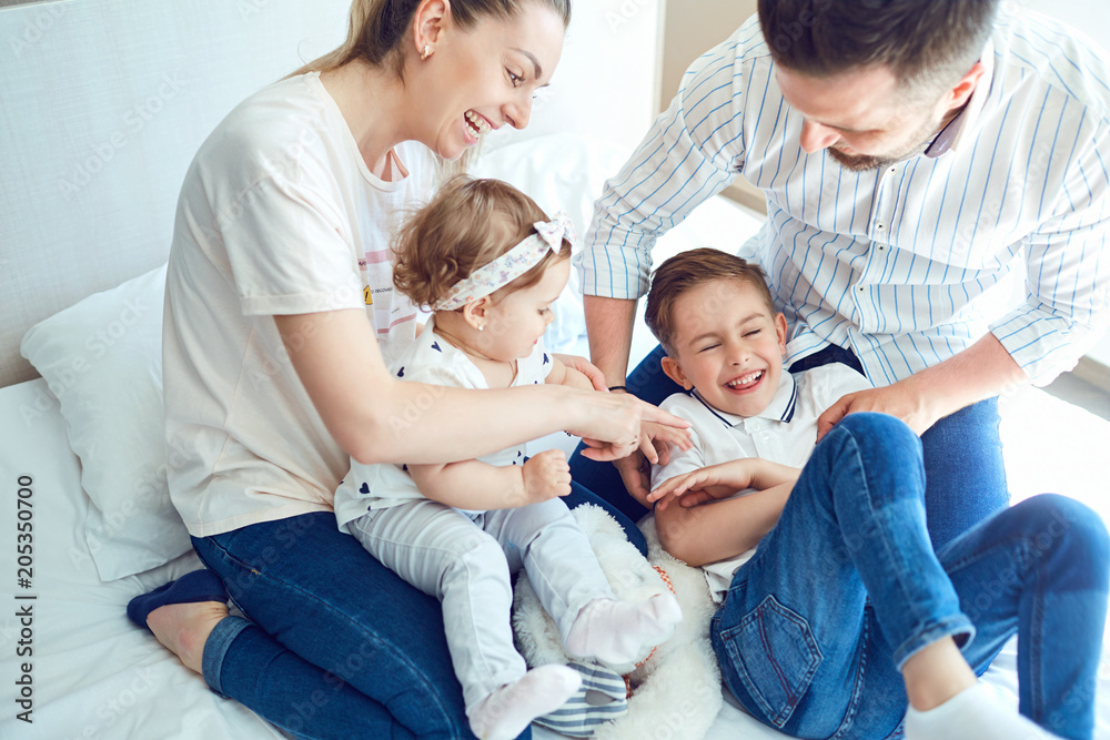 Happy family having fun playing lying on the bed in the bedroom. Happy family having fun playing lying on the bed in the bedroom.