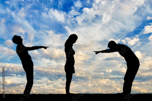 Silhouettes of two men laughing at a woman showing a finger at her