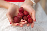 Female hands hold a handful of strawberries