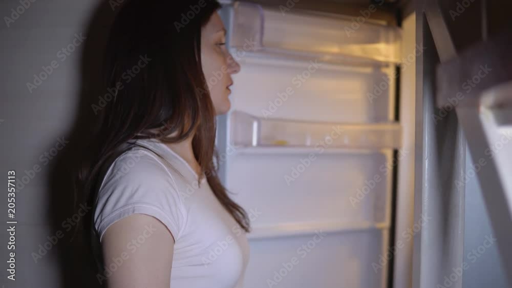 Young brunette woman by the night at the refrigerator. Young brunette woman by the night at the refrigerator.