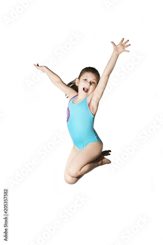Little caucasian female 7 years old girl in cyan swimming costume jumping on white background. Summertime, sport and ricreation concept.