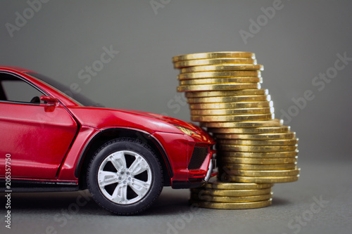 road traffic accident, car insurance concept. red car hit pile of coins