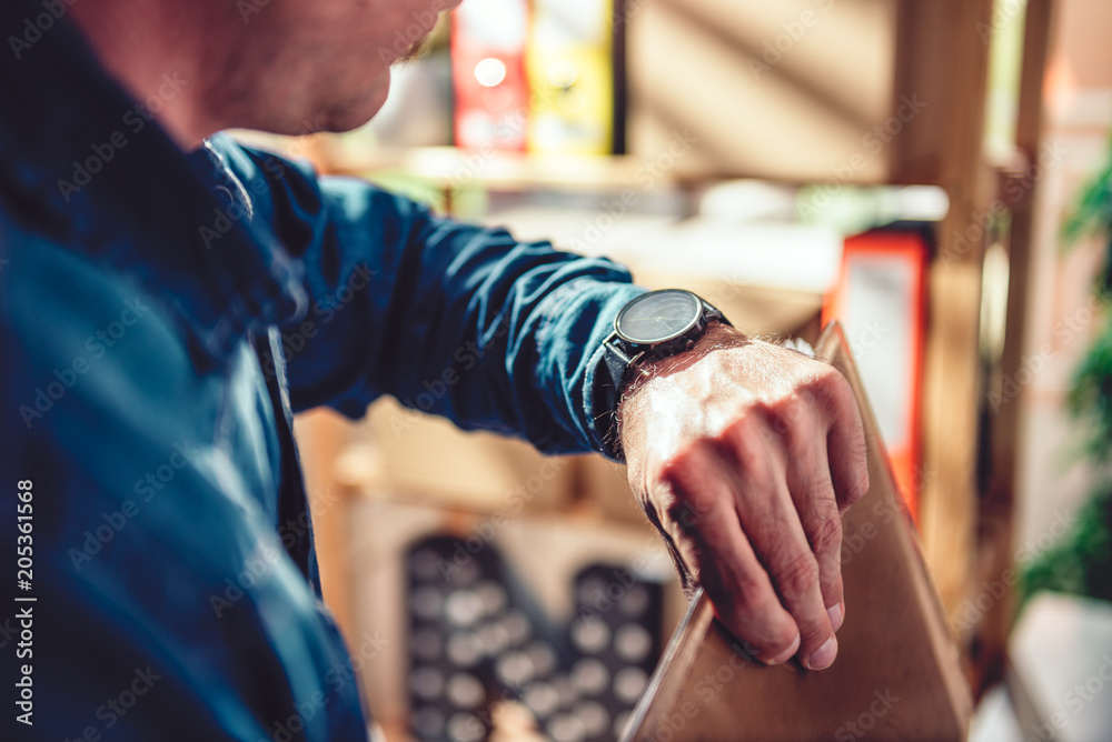 Man looking at wristwatch at the office Man looking at wristwatch at the office