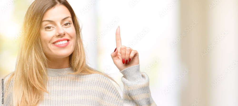 Young beautiful woman happy and surprised cheering expressing wow gesture pointing up Young beautiful woman happy and surprised cheering expressing wow gesture pointing up