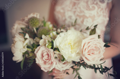 Wedding bouquet of white peony and coffee roses. Lots of greenery.