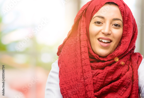 Young arab woman wearing hijab confident and happy with a big natural smile welcome gesture