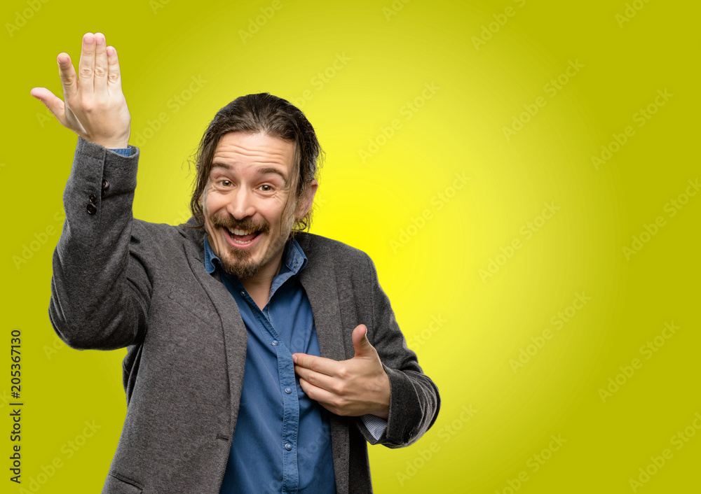 Handsome young man happy and surprised cheering expressing wow gesture pointing up Handsome young man happy and surprised cheering expressing wow gesture pointing up