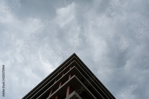 Bottom view of modern building in business district against overcast sky