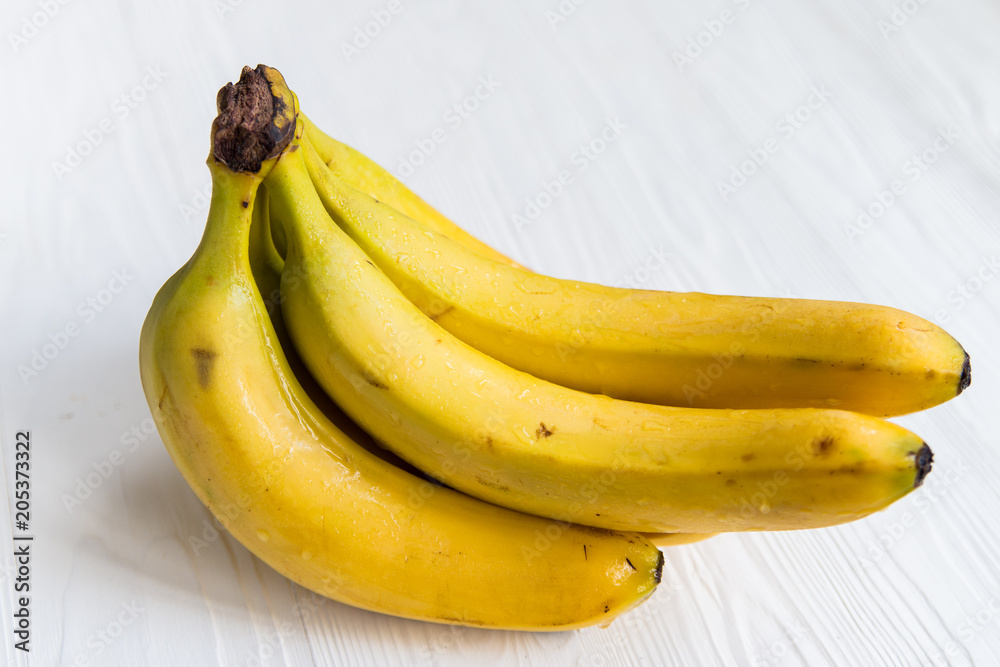 Bunch of bananas on white wooden surface close