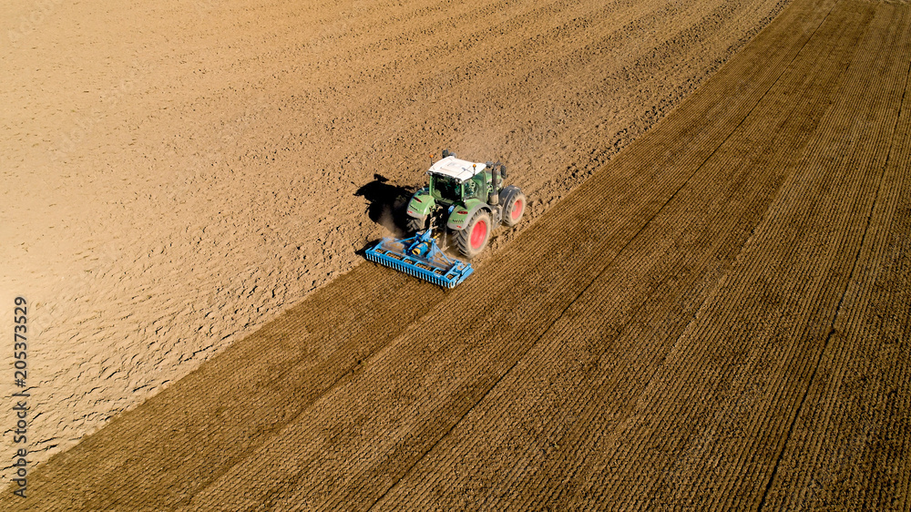 Naklejka premium Tracteur labourant un champ dans la campagne, France