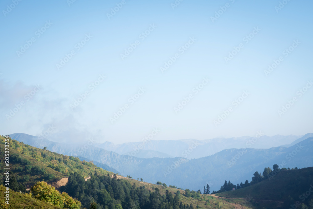 blue sky over wooded mountains
