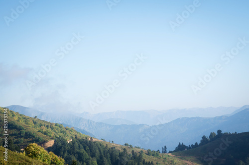 blue sky over wooded mountains